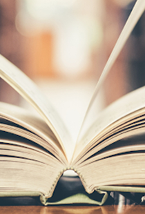 Aufgeklapptes Buch liegt auf einem Tisch