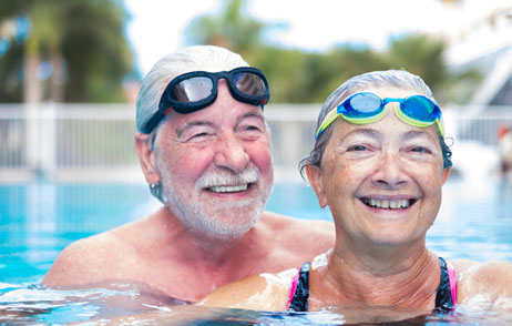Älteres Paar mit Schwimmbrillen zusammen im Pool mit Schwimmbrillen