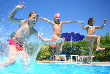 Kinder springen in den Pool