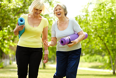 zwei Frauen im Park mit Sportmatten