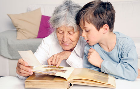 Oma schaut mit Enkel ein Fotoalbum an