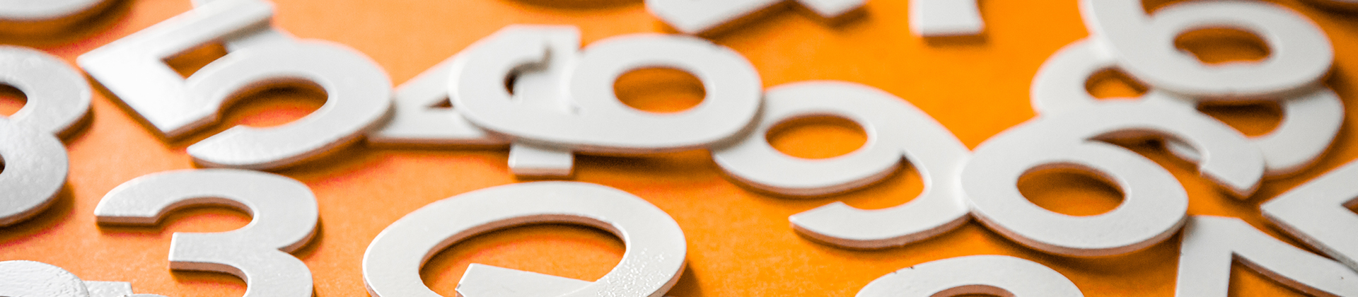 Weisse Zahlen als Puzzle auf orangenem Untergrund