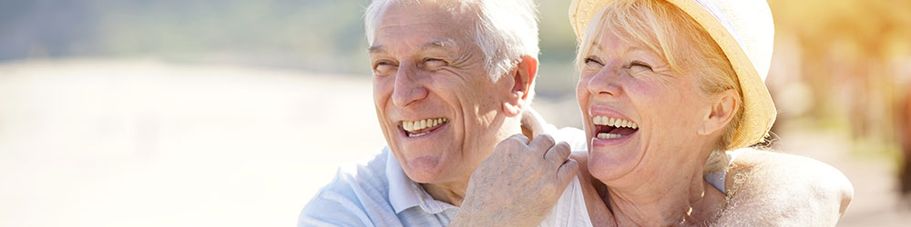 älteres Paar am Strand glücklich am lachen