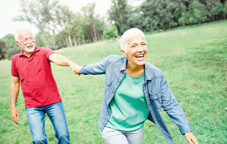 Ein Paar mittleren Alters ist im Park unterwegs und freut sich