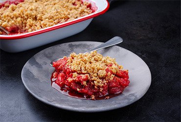 Crumble mit roten Beeren auf Teller