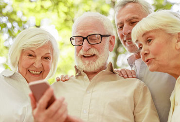 Senioren schauen gemeinsam in ein Smatphone