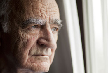Einsamkeit lässt das Gehirn schrumpfen Älterer Mann schaut traurig aus dem Fenster