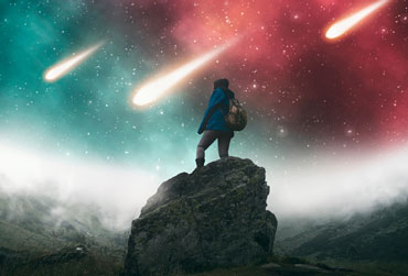 Person steht auf Felsen - Meteroidenschauer