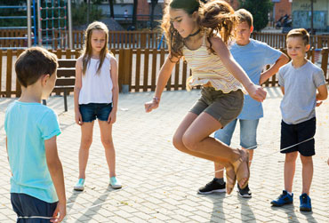 Gummitwist Eine Gruppe Kinder spielen Gummitwist