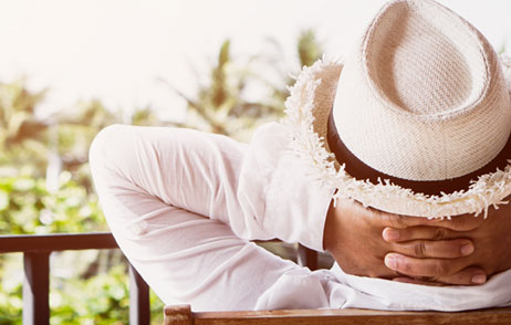 Urlaub auf Balkonien Mann sitzt auf dem Balkon und entspannt
