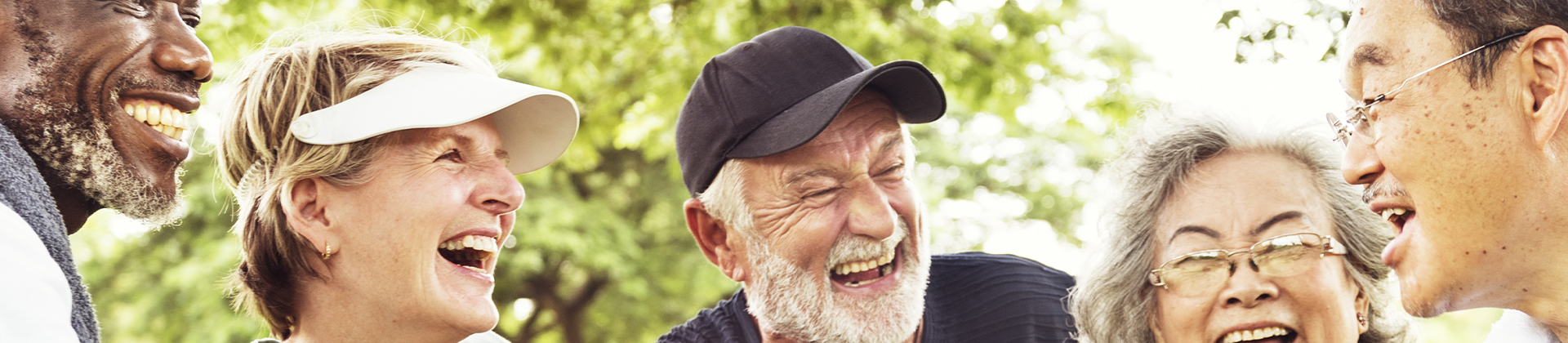 Eine Gruppe älterer Menschen lacht zusammen im Park