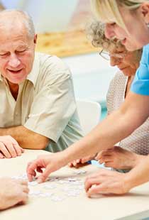 In Gesellschaft spielen & rätseln Gruppe von älteren Menschen zusammen beim Spielen