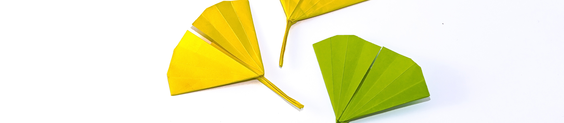 Zu Ginkgo-Blättern gefaltetes Origami in grün und gelb